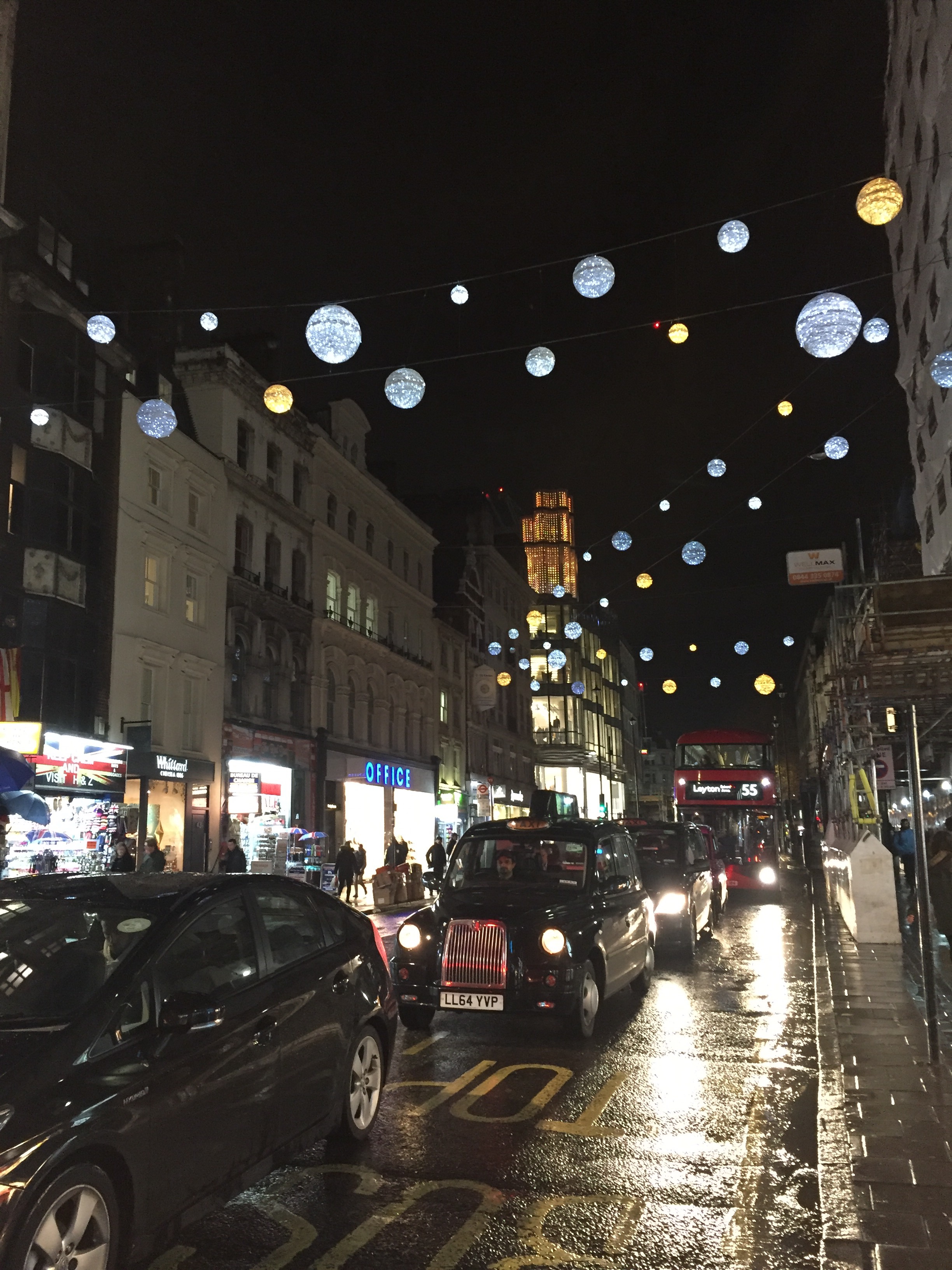 Oxford street, decorated for the holidays. Also notice the iconic London cab and double decker bus.