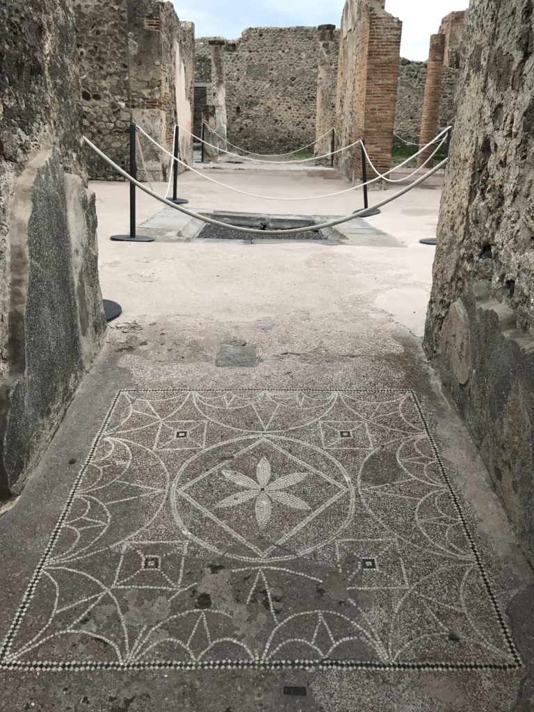 What looks like an entrance to a normal house in Pompeii, decorated with mosaics