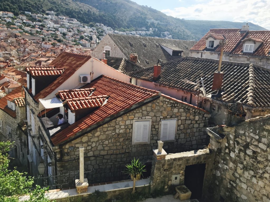 Can you find the man read 'Steve Jobs' by Water Isaacson from the Dubrovnik wall? Clue, he's sitting in his balcony. 