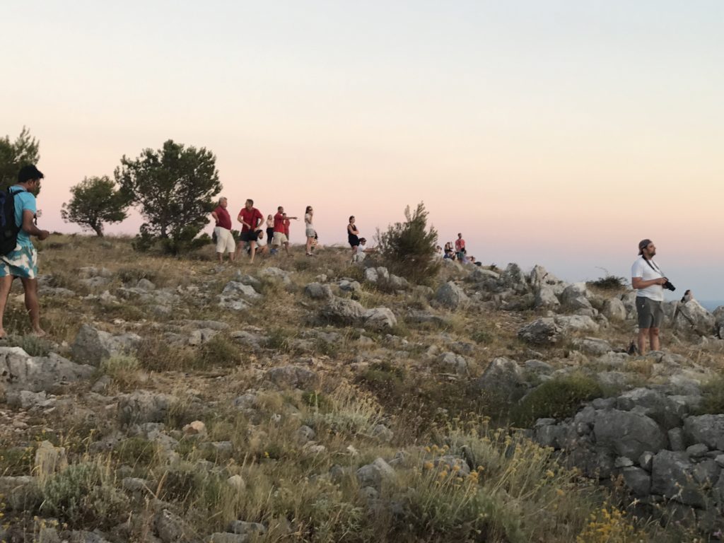 People camp on the hillside to enjoy the view of the sun setting in the Adriatic. 