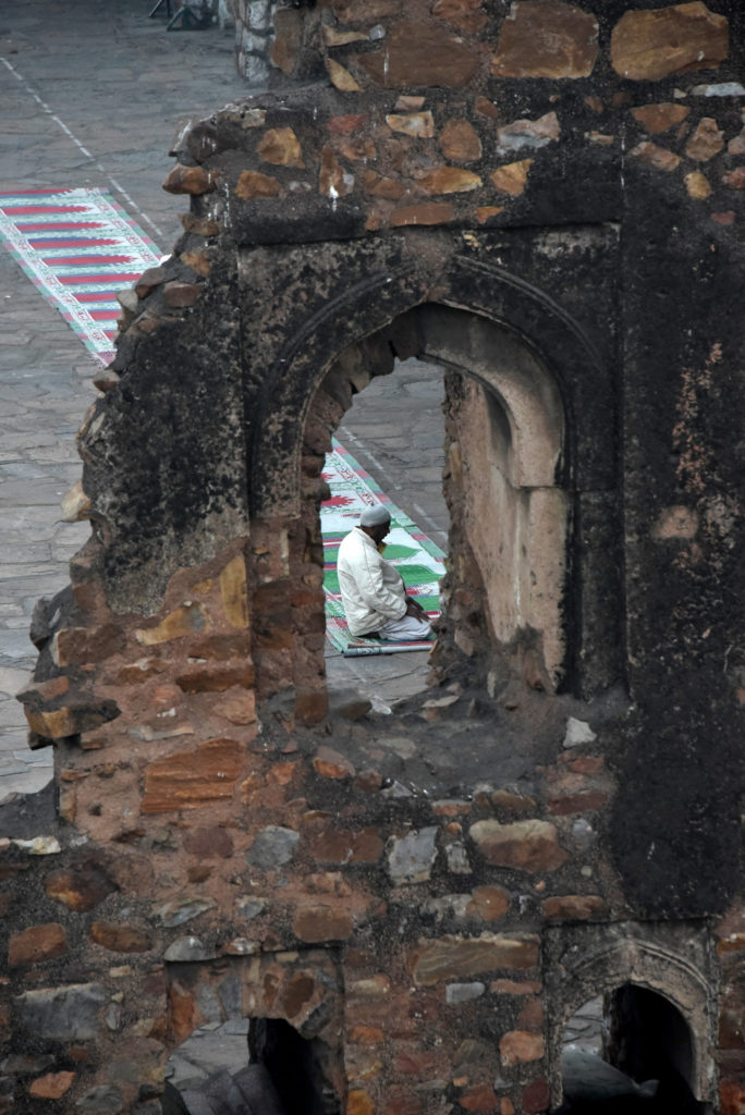 A practitioner praying in the open courtyard of Jami Maszid in Feroz Shah Kotla, Delhi