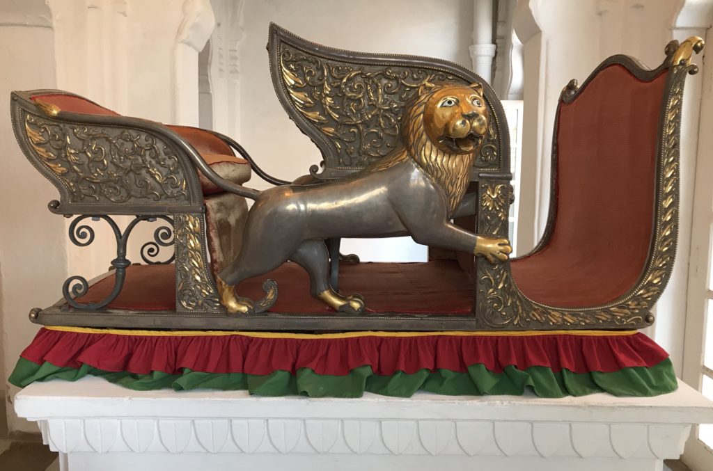 The elephant howdah (the King’s seat on an elephant) is made on a wooden frame and embossed with silver. It has iron rings to strap onto the elephant. It’s from the 19th century. 