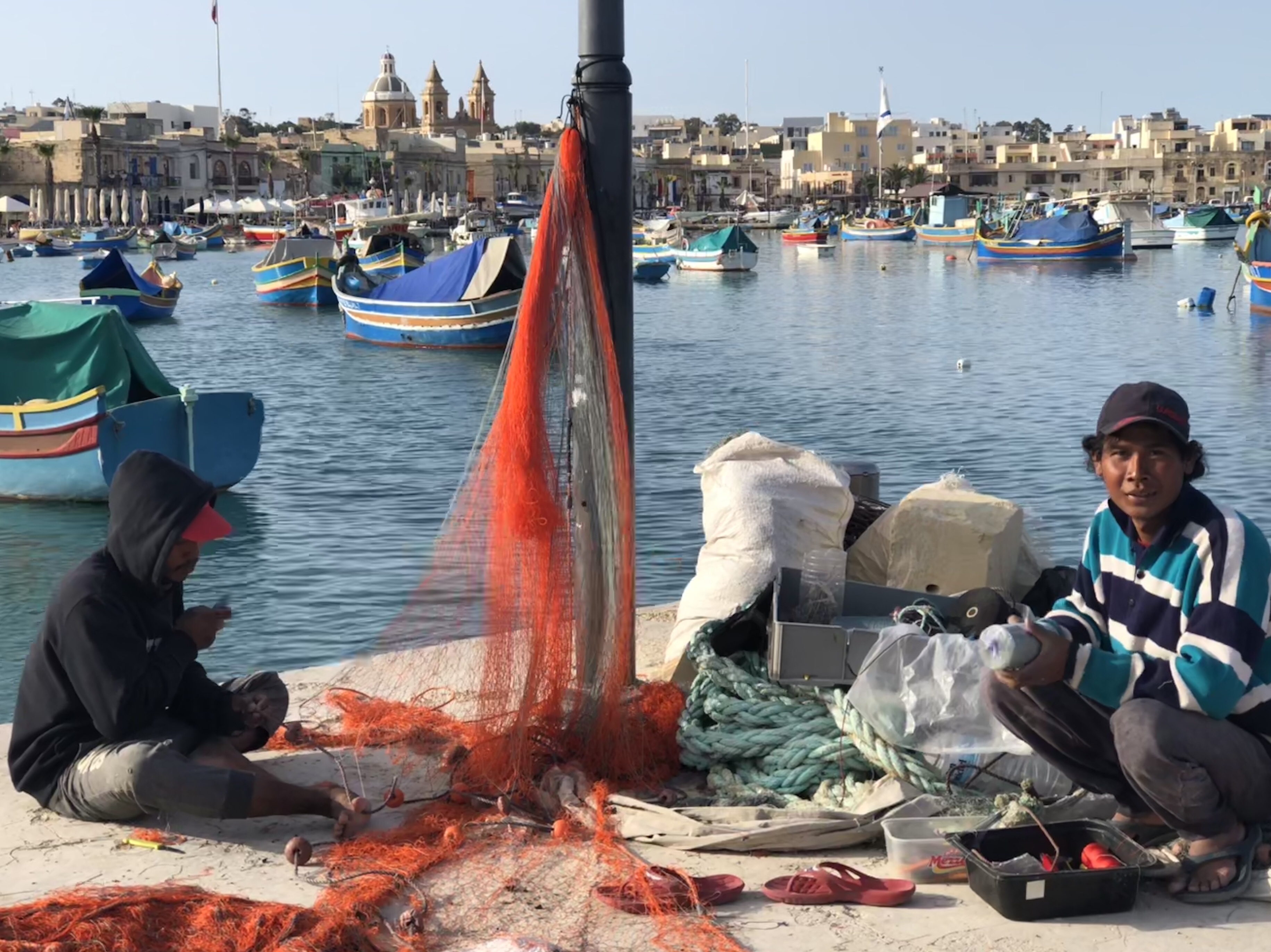 Migrant workers repairing nets in Marsaxlokk 