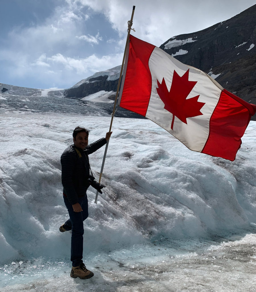 Waving the Canadian flag Athabasca Glacier, a tongue of the Columbia Icefield, a must-visit spot when visiting the Canadian Rockies.