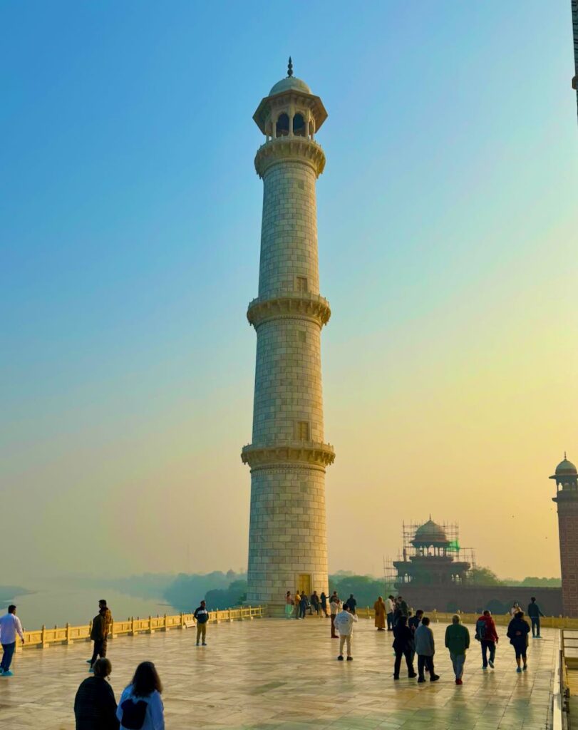 One of Taj Mahal's four minarets with the Yamuna river, at sunrise