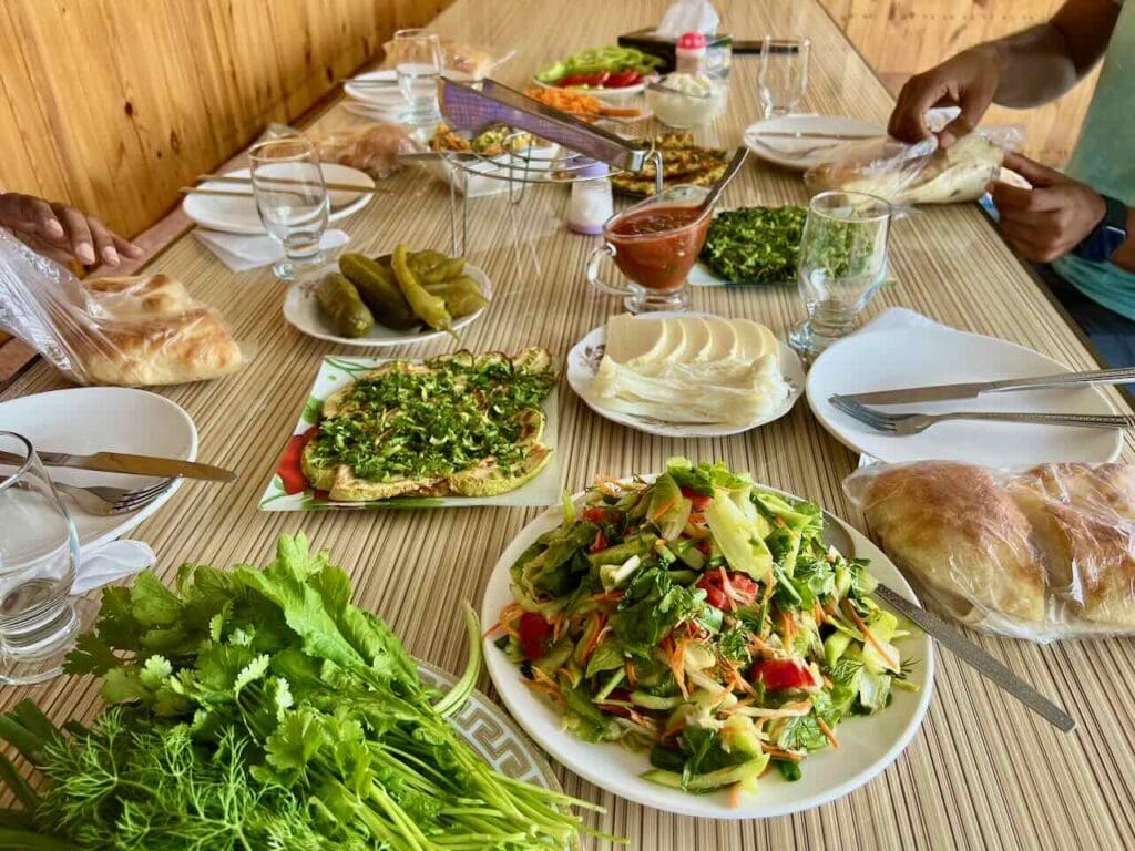 A plentiful meal for two on a farm in Armenia - salads, freshly baking bread, roasted eggplants, heart of palms, sauces etc