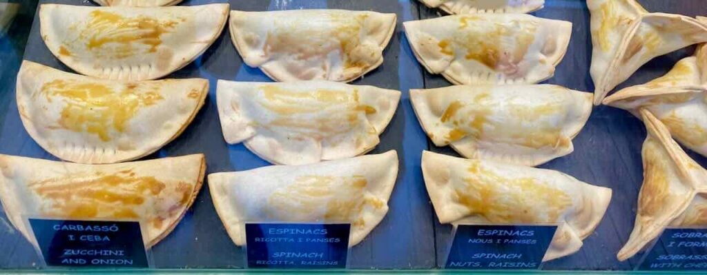 Empanada shop in Barcelona across from Sagrada Familia, offering vegetarian options like spinach, nuts, zucchini empanadas 