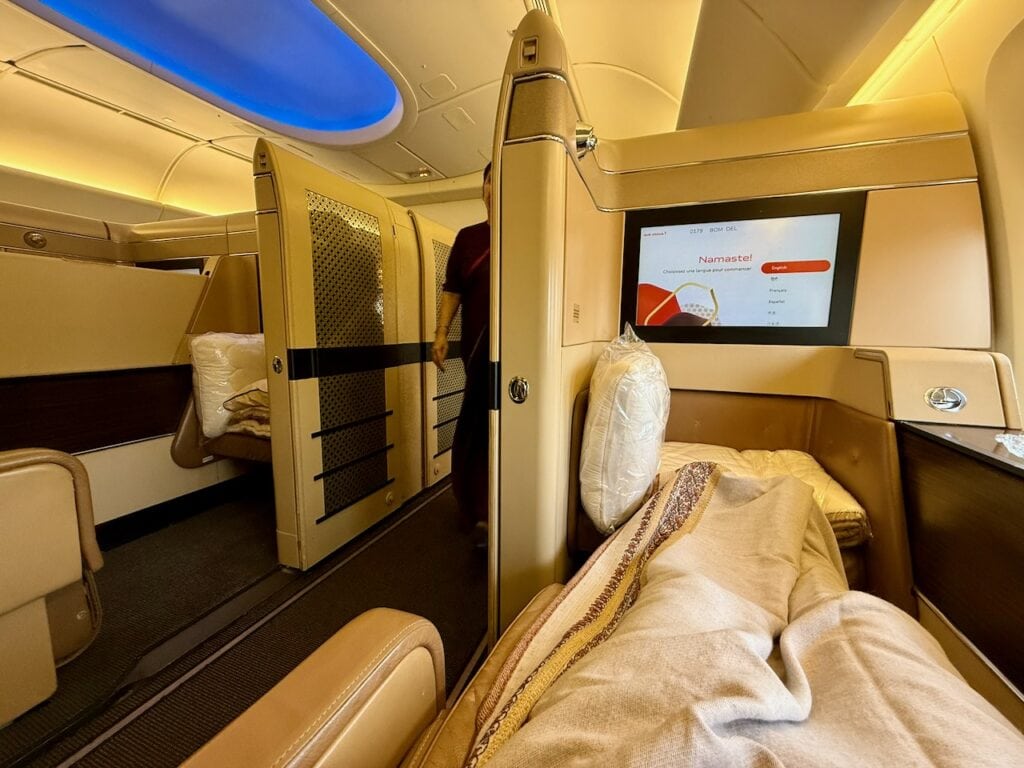 Air India business class lie-flat bed made up for sleep with duvet and pillow before departure