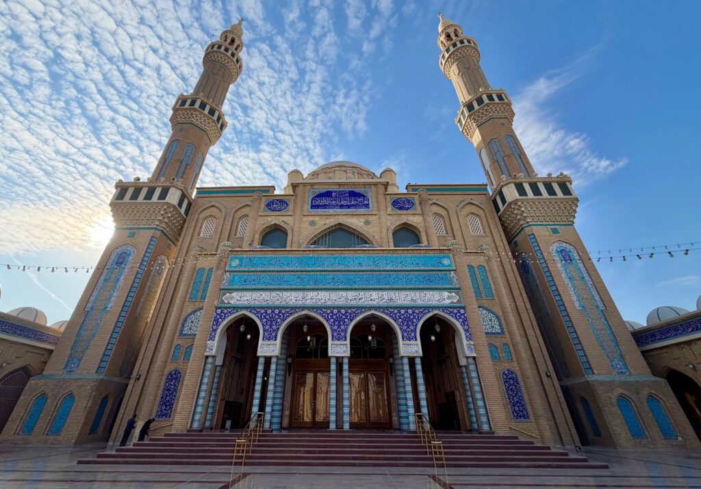 The facade of Jalil Khayat Mosque in Erbil showing blue tilework and twin minarets against the sky, Iraqi Kurdistan