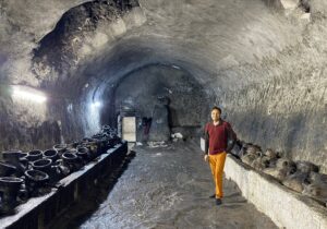 Detail of ancient clay oil pots against a stone wall densely covered with generations of handprints at the Lalish Yazidi temple, Iraqi Kurdistan