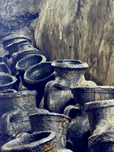 Close-up of ancient blackened clay oil pots stacked on stone shelves in the sacred underground chamber at the Lalish Yazidi temple, Iraqi Kurdistan
