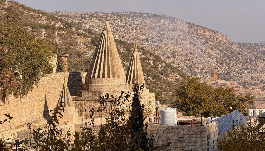 The distinctive conical shrines of the Lalish Yazidi temple rising above the valley walls in the sacred mountain valley, Iraqi Kurdistan