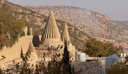 The distinctive conical shrines of the Lalish Yazidi temple rising above the valley walls in the sacred mountain valley, Iraqi Kurdistan