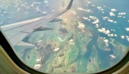 Aerial view of Key West, Florida from a long-haul flight window, showing turquoise waters and island chains