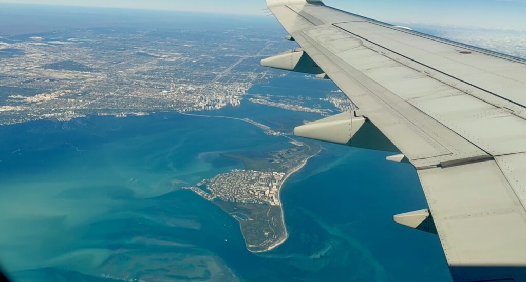 Aerial view of Miami Beach and Biscayne Bay from a long-haul flight window