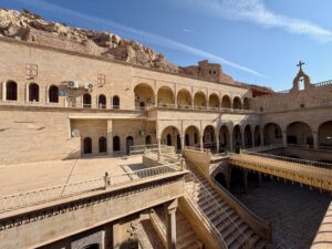 The arcaded inner courtyard of Mar Mattai Monastery with stone arches and tiled floors, northern Iraq