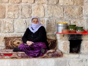 A Yazidi woman in a purple dress walking through the courtyard of the Lalish Yazidi temple complex, Iraqi Kurdistan