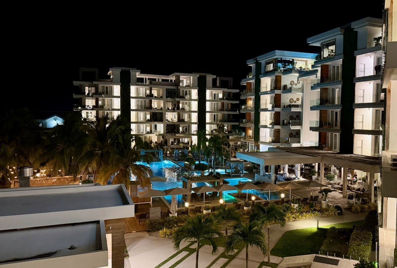 Alaia Belize Marriott Autograph Collection resort at night with illuminated pools and palm trees