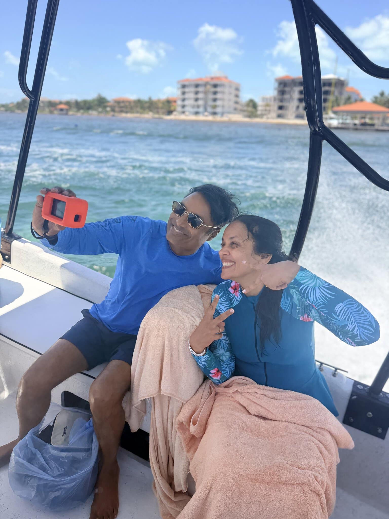 Couple taking a selfie with a DJI Osmo Action 5 camera on the snorkeling boat heading to the reef in San Pedro, Belize