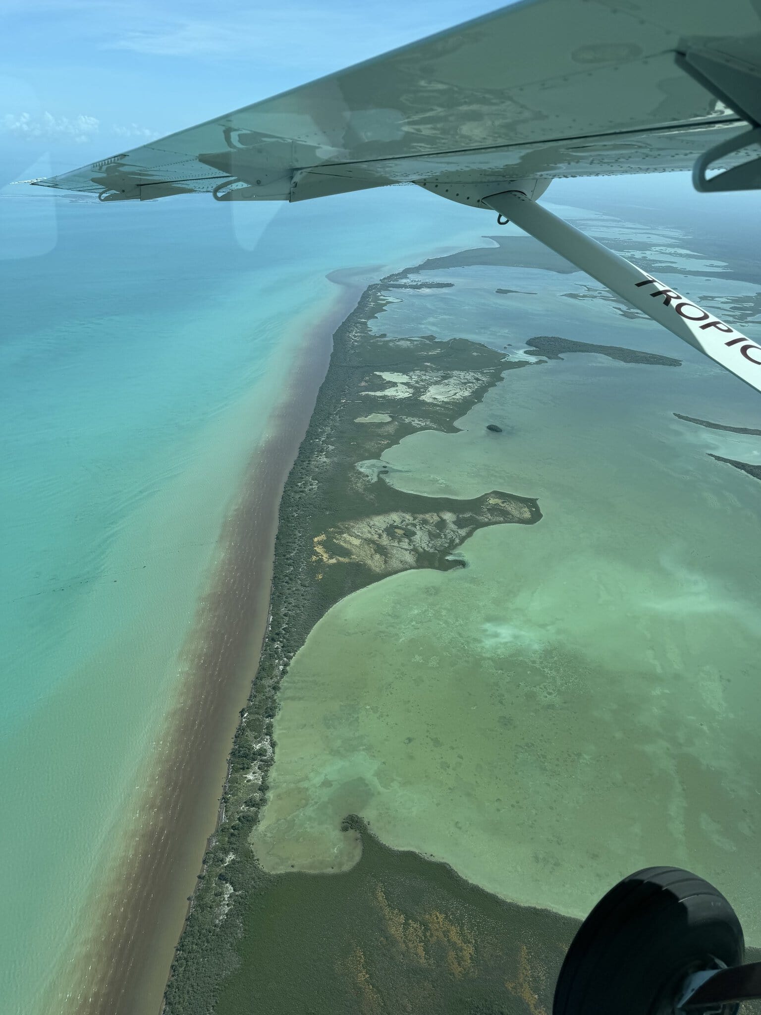 Tropic Air wing visible when flying over the narrow strip of land between the ocean and Midwinters lagoon in mainland Belize, south of San Pedro