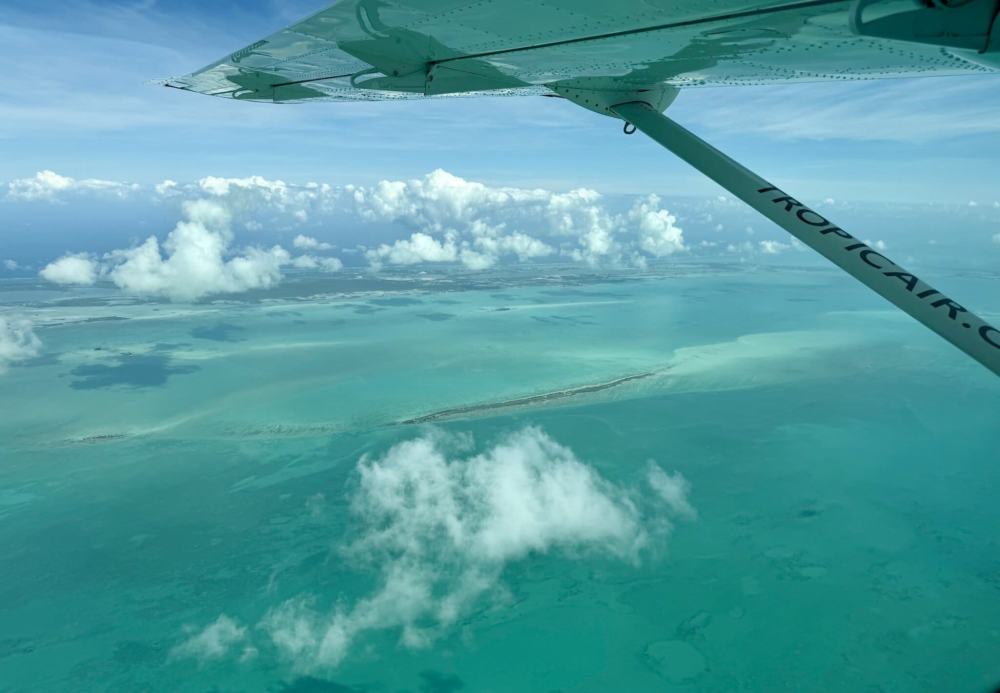 Tropic Air plane wing over the turquoise Belize reef and cayes during the 14-minute flight from Belize City to San Pedro