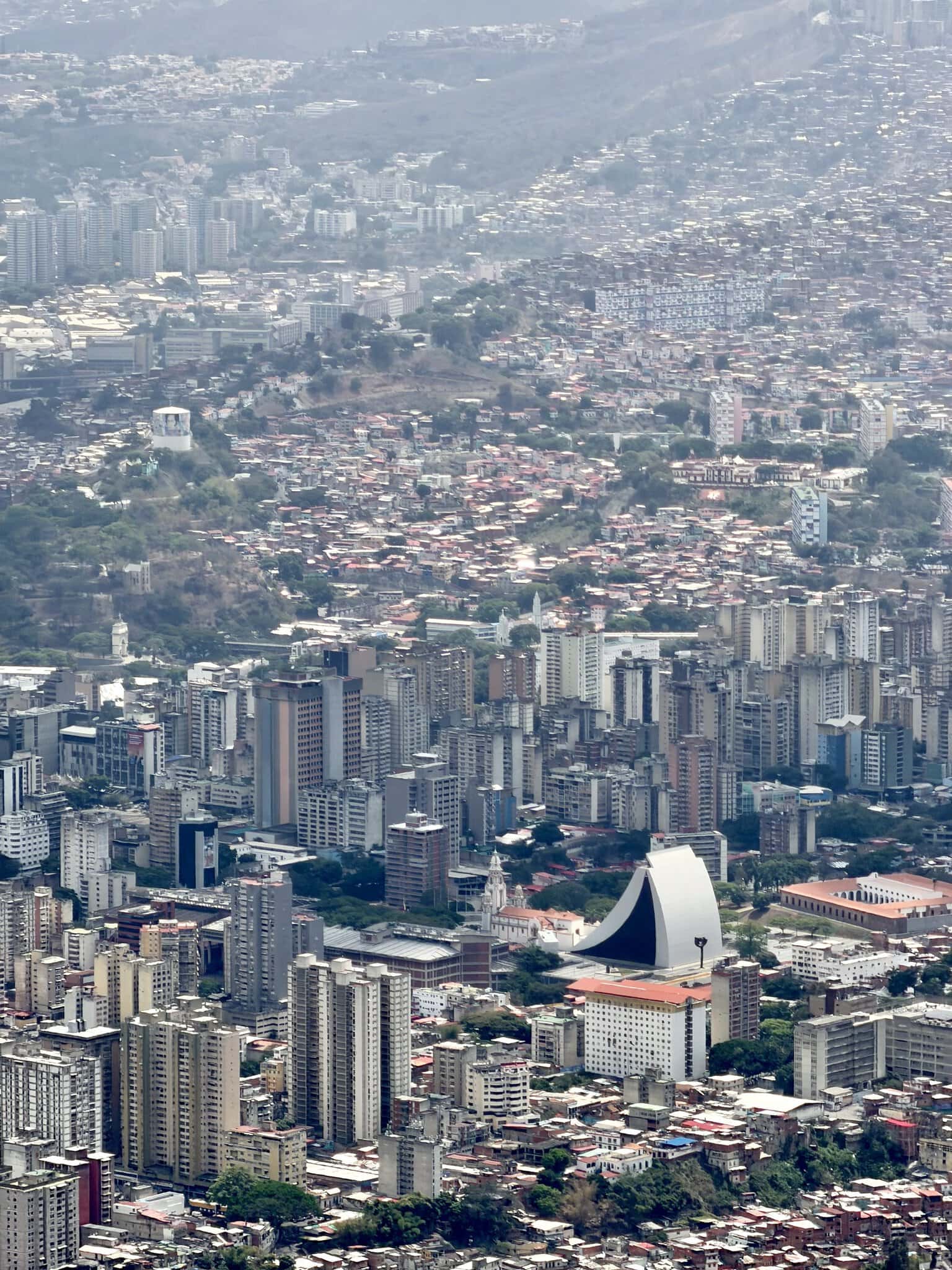 Sweeping aerial view of dense Caracas cityscape with barrios and skyscrapers from El Avila mountain