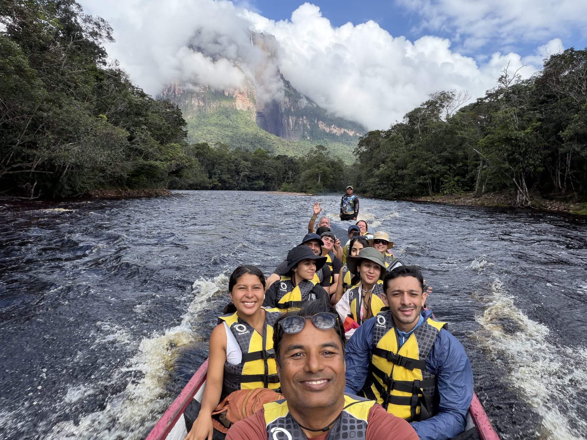 Group of tourists in yellow life jackets on a motorized canoe approaching Angel Falls Venezuela